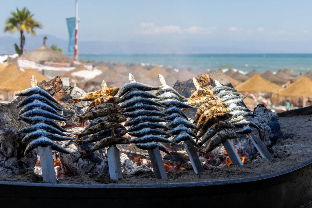 Close-up of slow roasting sardines in a boat along the beach of Torremolinos, Costa del Sol.
