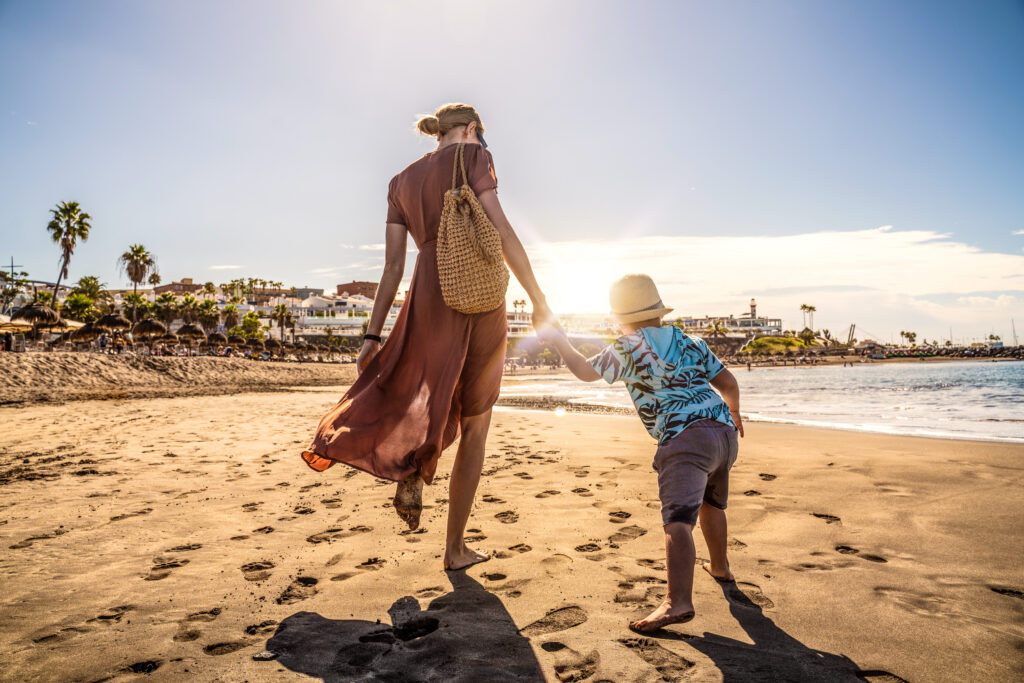 Mother annd child walking along a sandy beach